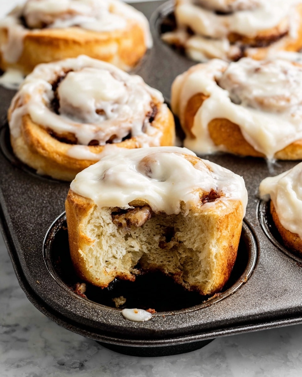 A black muffin pan with 12 round slots is shown in two side-by-side images on a white marbled surface. The left image shows raw cinnamon rolls arranged evenly in each slot. Each roll consists of layered dough with a spiral pattern of light beige dough and darker brown cinnamon filling visible in three to five swirled layers. The dough looks soft and slightly puffy, revealing a bit of flour dust on top. The right image shows the same cinnamon rolls after baking, with the dough turning a golden-brown color and the cinnamon layers darkened in the spiral. Each roll has a rounded top with a slightly toasted texture, giving a warm and inviting look. Photo taken with an iphone --ar 4:5 --v 7
