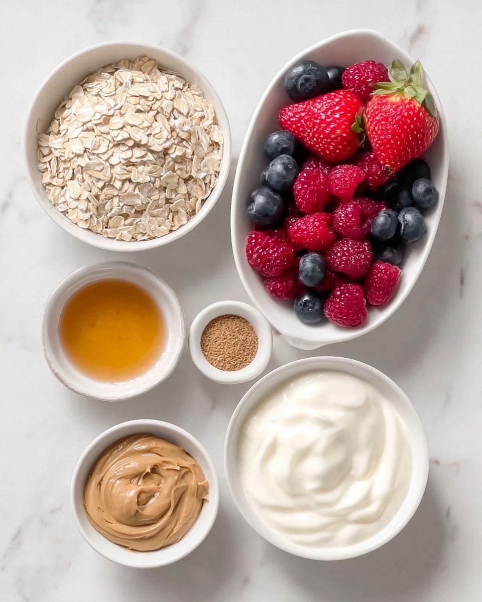 The image shows five white bowls and one white boat-shaped dish arranged on a white marbled surface. The largest bowl at the bottom right is filled with smooth, thick white yogurt. To the left of it is the boat-shaped dish holding bright red strawberries, deep red raspberries, and dark blue blueberries. Above the yogurt is a bowl with smooth light brown peanut butter. Next to that is a smaller bowl filled with light golden honey. Above the honey bowl is a small bowl containing a light brown powder, likely cinnamon or a spice. The largest bowl at the top left is full of pale, flat rolled oats with a rough texture. All items are neatly arranged and the image is clear with natural lighting, photo taken with an iphone --ar 4:5 --v 7