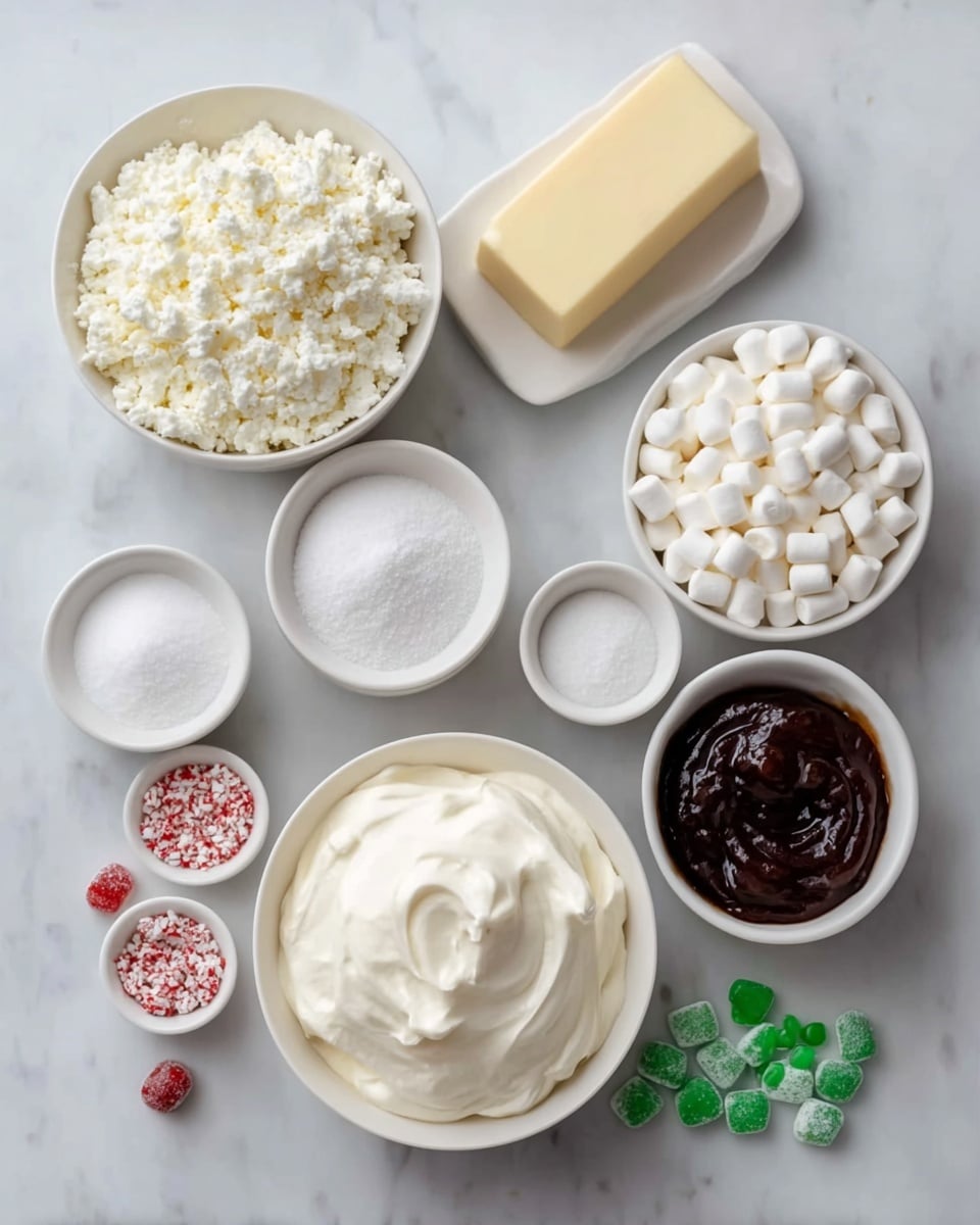 The image shows eight white bowls and dishes arranged neatly on a white marbled surface. The largest bowl at the bottom left contains smooth, creamy white whipped topping with soft peaks. Next to it on the right is a bowl filled with small, cylindrical white marshmallows. Above the whipped topping is a larger bowl full of fluffy, crumbly white cottage cheese. To the top right is a small bowl with thick, dark brown shiny sauce or syrup. In the center near the top is a solid rectangular block of pale yellow butter. Surrounding the main bowls are smaller white bowls containing fine granular white sugar, light brown vanilla extract, white granular fine dry powder, and green candy-coated chocolate pieces with a few red candies scattered around them. The composition is clean and organized, showing each ingredient clearly. Photo taken with an iphone --ar 4:5 --v 7