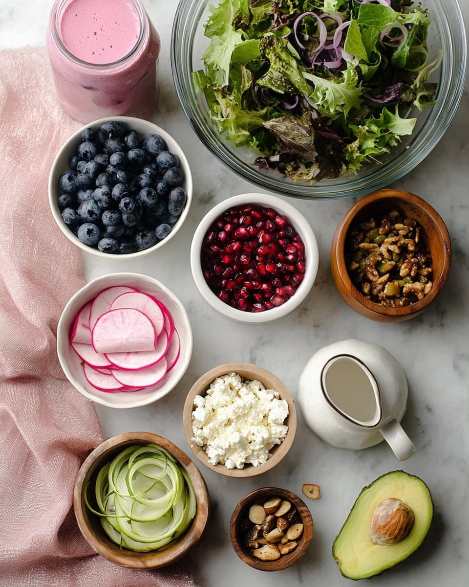 A white bowl filled with a colorful salad sits on a white marbled surface. The bottom layer is made of mixed fresh green lettuce leaves with bright and dark green shades. On top, there are thin slices of light green avocado fanned out in small groups, and round slices of pink and white watermelon radish with a smooth texture. Scattered around are deep blue blueberries, shiny red pomegranate seeds, and light purple thin onion rings. Small clusters of toasted brown nuts add a crunchy look. White crumbled cheese is sprinkled evenly over everything, and a smooth pink dressing is drizzled across the salad, adding a glossy texture. A glass bottle with pink dressing is visible in the top left corner. Photo taken with an iphone --ar 4:5 --v 7