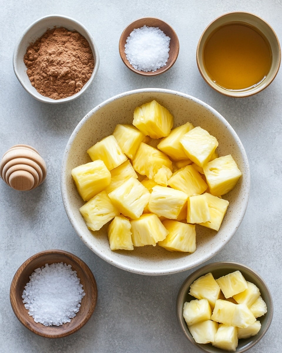A white long rectangular plate holds six circular, grilled pineapple slices arranged in a neat row, each slice showing caramelized brown edges with a golden-yellow center and slight grill marks. The pineapples have a slightly glossy texture from the grilling process. A small green parsley leaf is placed at the front right corner of the plate. The plate sits on a white marbled surface with a light blue cloth partially visible on the left side and a blurred background showing cinnamon sticks on the right. The photo taken with an iphone --ar 4:5 --v 7