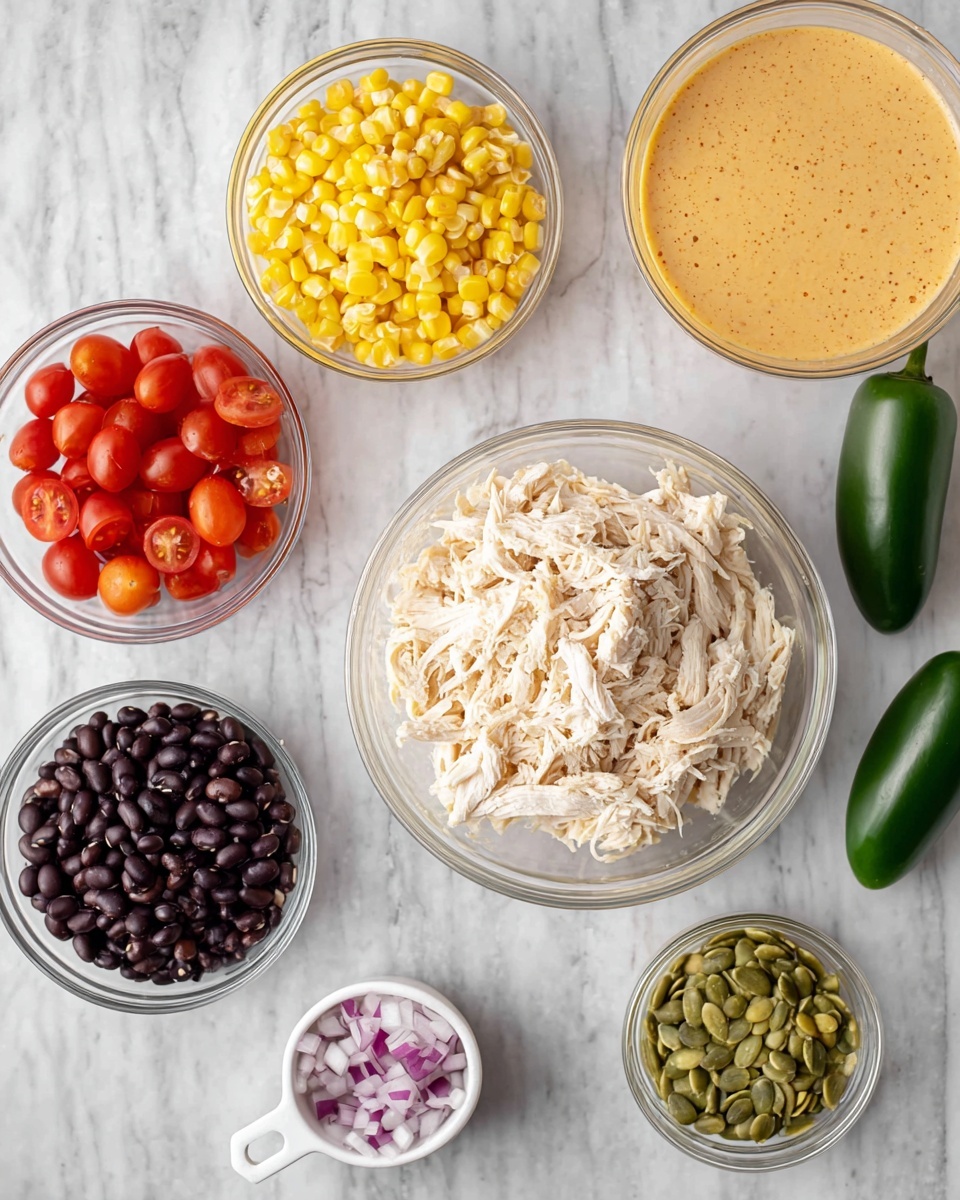 The image shows several clear glass bowls and a white measuring cup placed on a white marbled surface. In the center is a large bowl with shredded white chicken, surrounded by smaller bowls holding bright yellow corn kernels, deep red cherry tomato halves, black beans, and green pumpkin seeds. A white measuring cup contains chopped red onions. To the right there is a bowl with creamy, light orange sauce, and near the bottom right a green jalapeño pepper lies on the surface. A beige cloth napkin is partly visible on the right side. photo taken with an iphone --ar 4:5 --v 7
